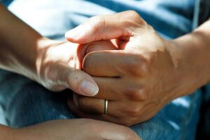 close up of two people holding hands at a hospital that utilizes medical waste disposal services